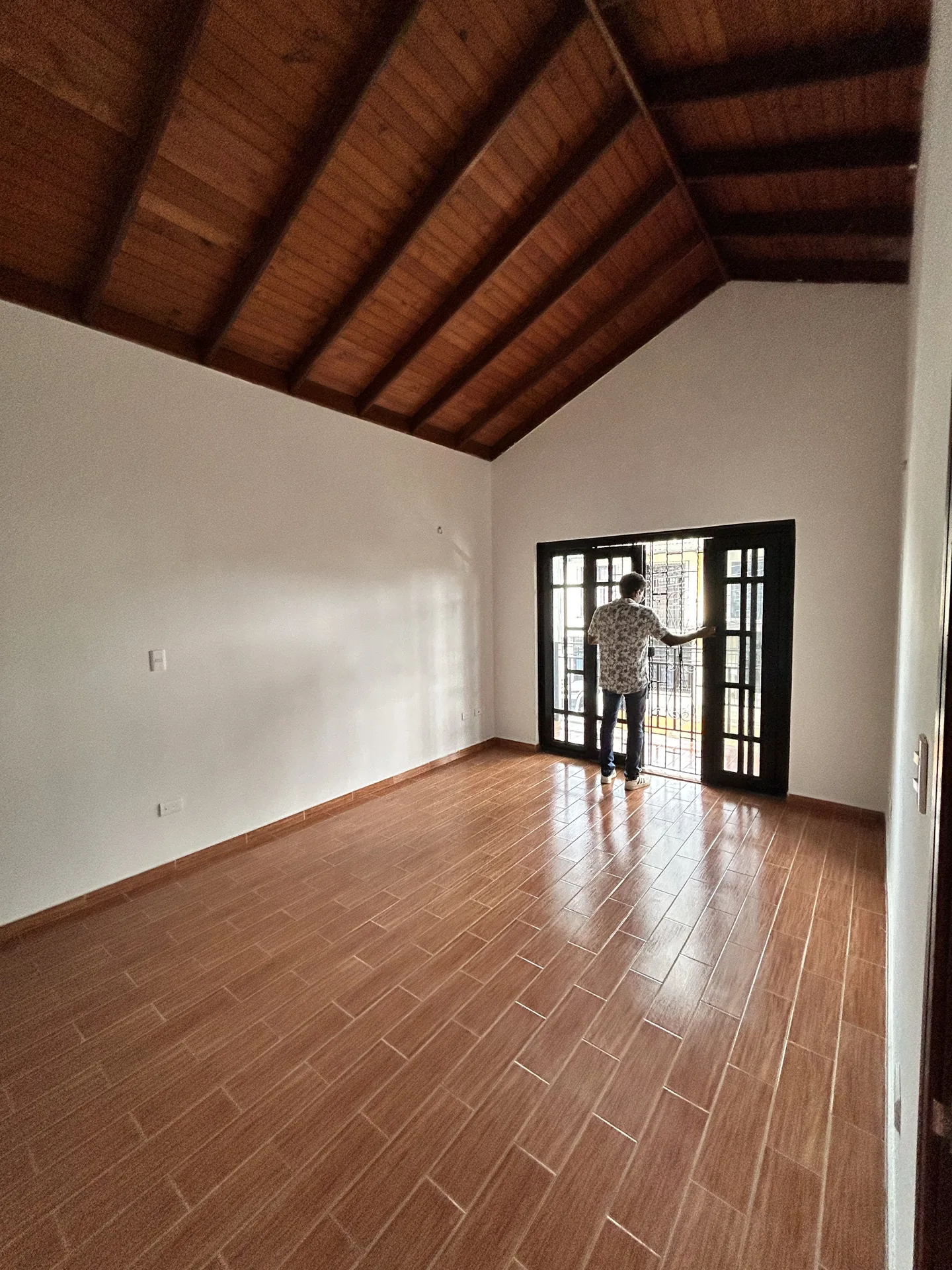 Sala renovada con techo de madera y piso nuevo
